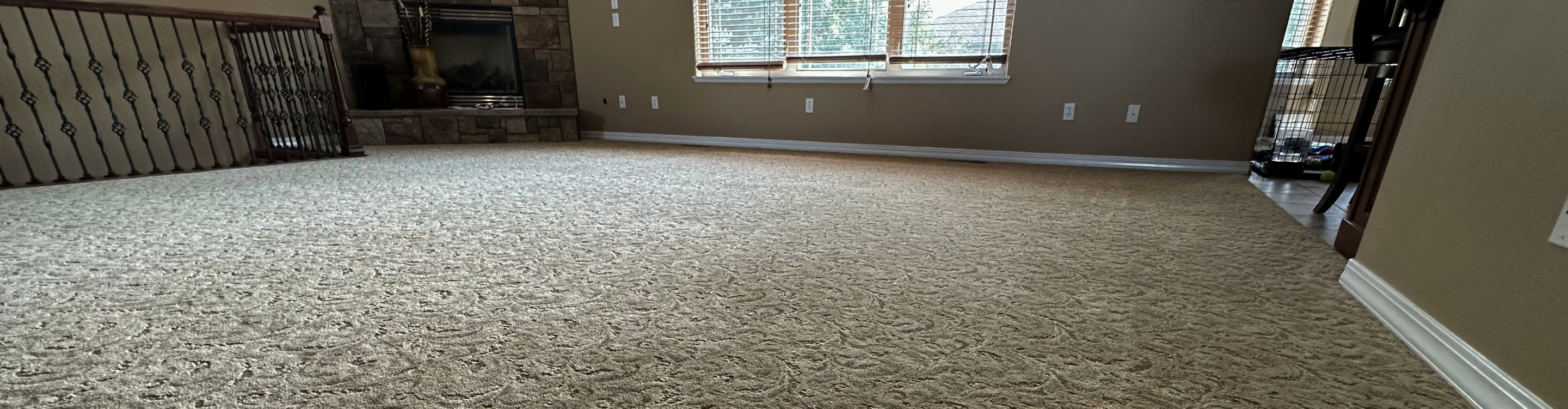 Living room with brown couch and two chairs, beige carpet