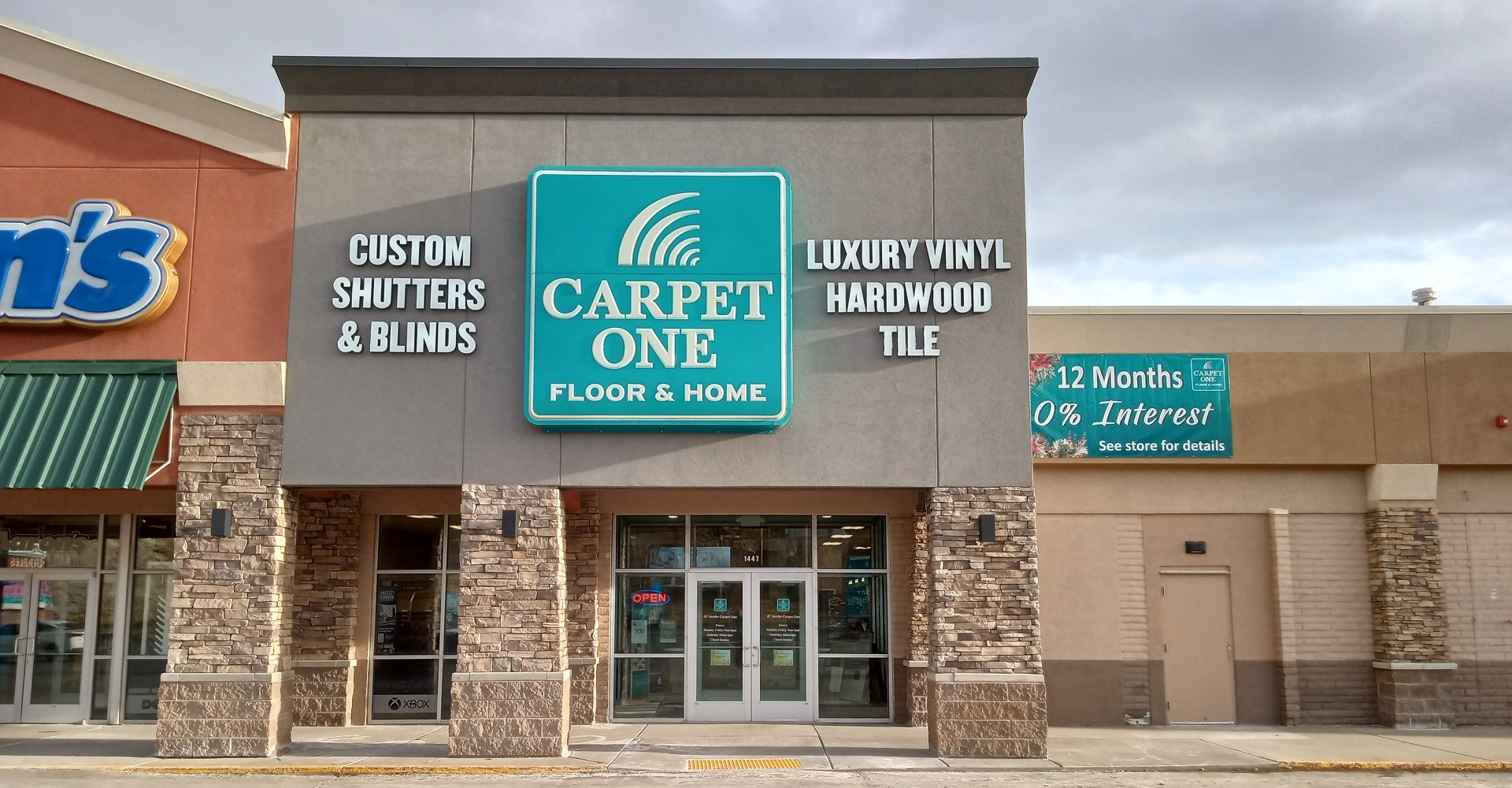 Dad pushing Daughter in Cardboard Box on Hardwood Floors